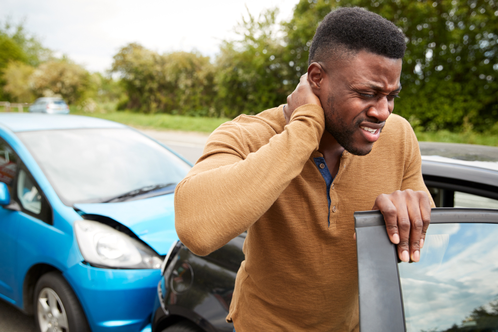 Man holding his injured neck after car wreck