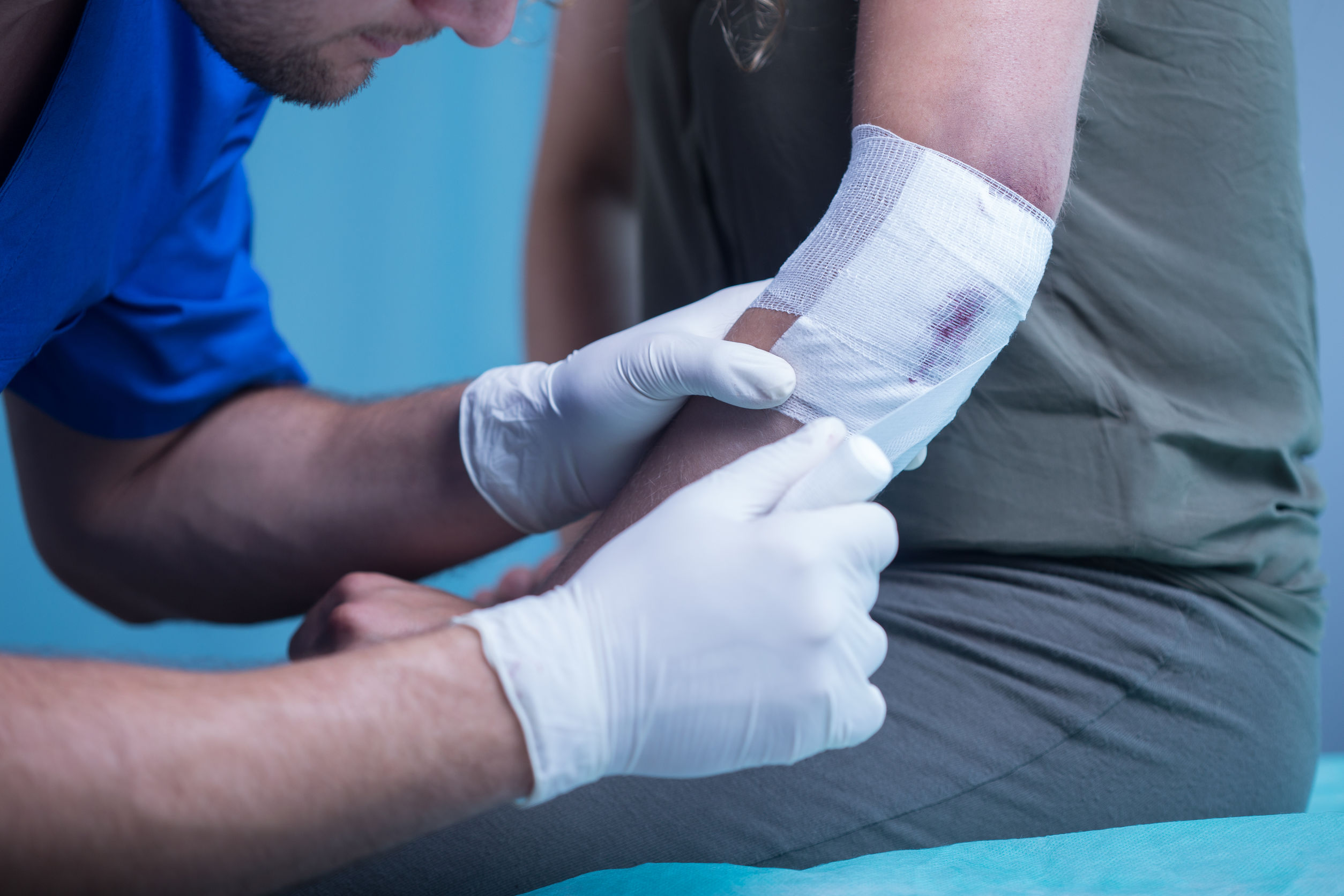Close-up of male paramedic dressing elbow wound