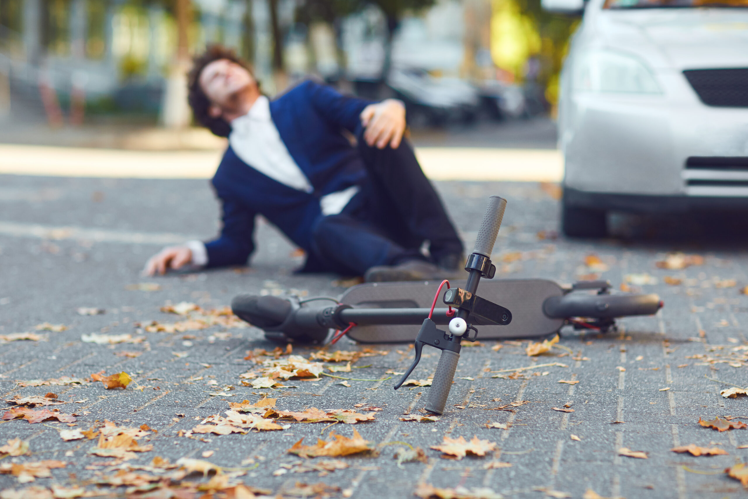 accident with an electric scooter. a man fell from a scooter on a city street.